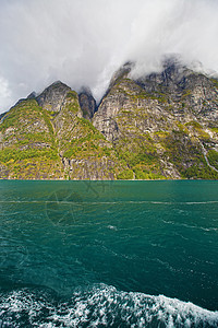 Geiranger 视图植物群峡湾美丽地区反射山坡国家石头巡航天空图片