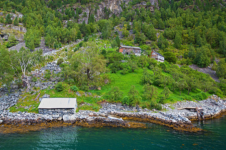 Geiranger 视图石头爬坡山坡峡湾树木蓝色小屋美丽农场海岸图片