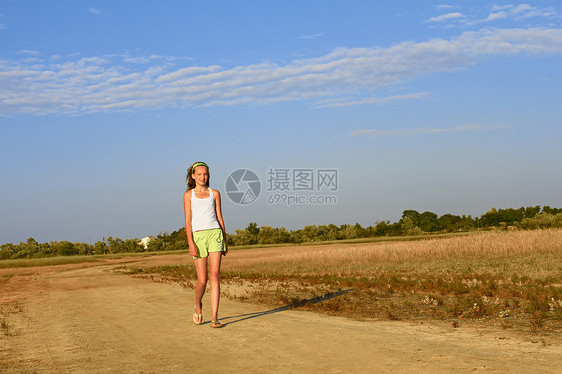 少女在沙沙路上行走图片