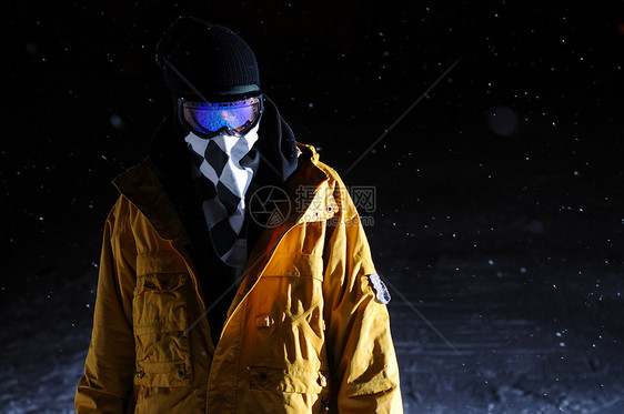 夜里站着的滑雪运动员的肖像运动滑雪者滑雪板单板橙子夹克下雪图片