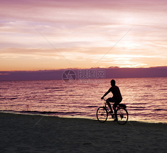 海滩上的自行车运动员追求旅游男性游客日落太阳闲暇乐趣旅行阳光图片