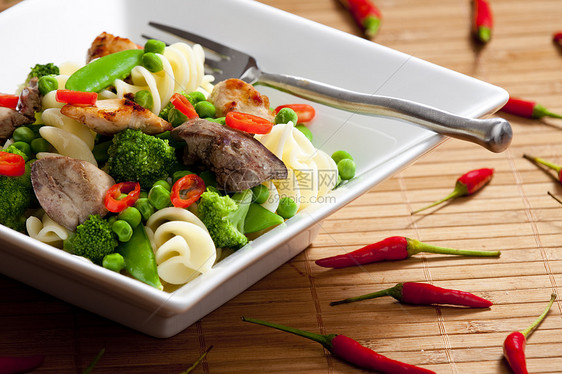 配绿色蔬菜和家禽肉的意大利面食物叉子美食胡椒熟菜盘子菜肴辣椒食品营养图片