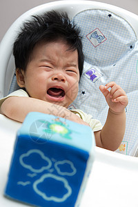 小亚洲女婴在高椅子上哭泣图片