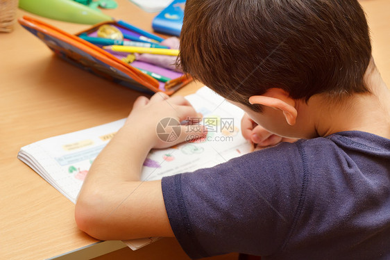 男孩用彩色铅笔 绘画水果做家庭作业思维桌子白色学校青少年教育学生字典水平房间图片
