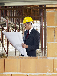 建筑工地建筑师职业男性人士工程师砖块中年人窗户检查安全帽成人图片