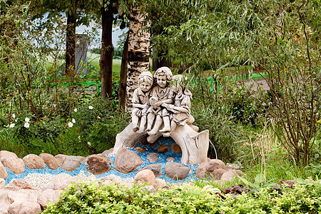 花园雕像乐趣石头客户树干衬套蓝色桦木朋友们绿色公园图片
