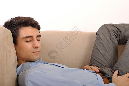男人睡在沙发上房间长椅成人闲暇衣服白色衬衫男性家具小憩图片