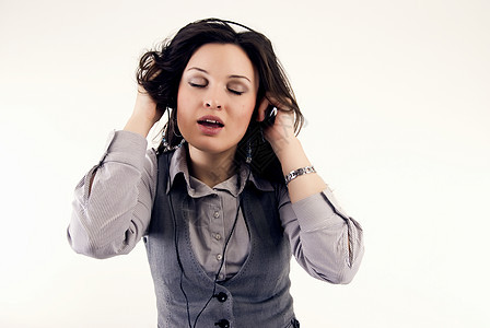 使用耳机的年轻女孩舞蹈收音机娱乐玩家女士享受音乐播放器闲暇立体声白色图片