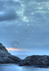 夜间的海蓝色阳光卵石石头海滩风景地平线海岸线天空薄雾图片