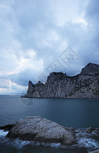 夜间的海场景巨石阳光卵石边缘天空海景海浪薄雾地平线图片