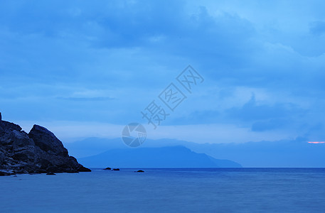 夜间的海边缘蓝色阳光风景卵石风暴巨石石头岩石薄雾图片