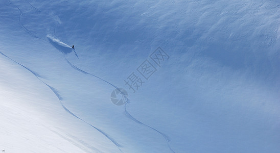滑雪运动员骑着滑坡下行图片