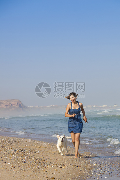 女孩带着她的狗喜悦幸福动物微笑乐趣跑步海滩猎犬朋友宠物图片