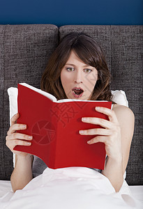阅读书籍房间成人白色黑发睡衣震惊情感注意力卧室女士背景图片