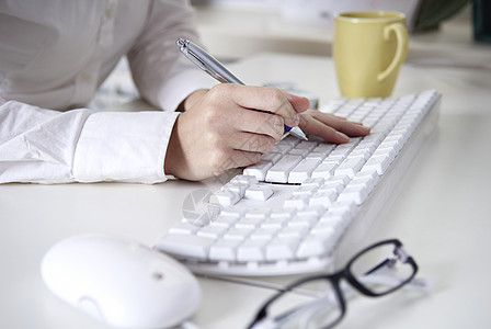 在白色计算机键盘上写作办公室家庭作业商务辅助数据活动技术咖啡盖电子电脑图片