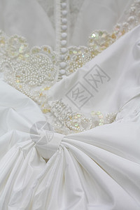 结婚礼服细节婚姻丝绸仪式女性按钮蕾丝裙子珍珠薄纱白色背景图片
