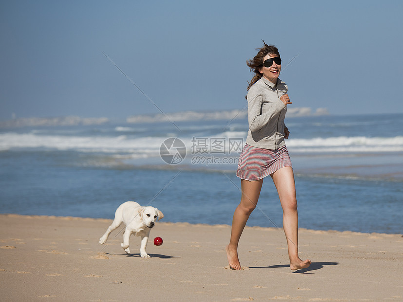 女孩带着可爱的狗猎犬人行道海洋朋友乐趣闲暇海滩动物微笑幸福图片