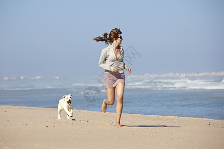 女孩带着可爱的狗幸福猎犬人行道闲暇海岸动物宠物海滩乐趣小狗图片