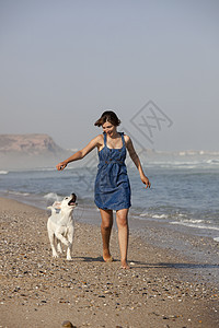 女孩带着她的狗人行道跑步友谊朋友海滩乐趣动物微笑宠物海洋图片