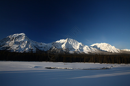 冬季落基山脉阴影旅行场景阳光照射白色水平风景草地树木丘陵图片