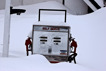 雪雪覆盖的旧汽油泵图片