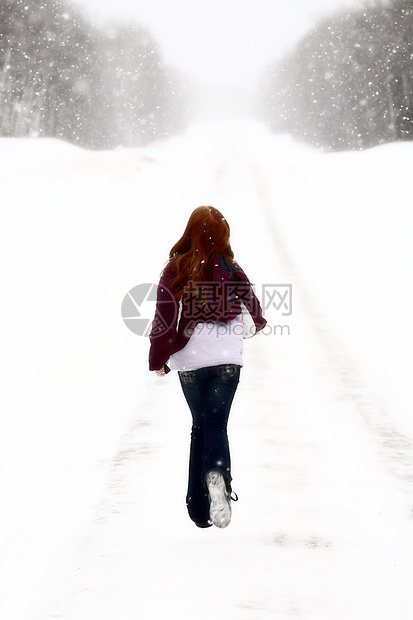 冬季红头女孩在森林路上跑下森林荒野旅行树木乡村国家下雪图片