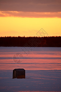 日落时在冰冻湖上钓鱼小屋冰钓美术树木旅行风景大草原乡村剪影图片