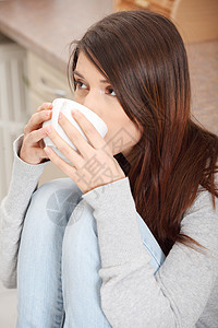 在厨房喝咖啡或茶的年轻女子成人杯子幸福妻子青年女士咖啡快乐享受女孩图片