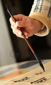 一个老人用笔笔做书法的老男人象形绘画手指工艺脚本墨水练习画笔文化文字图片