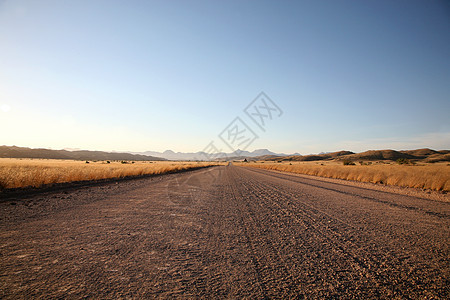 纳米比亚的碎石路极端爬坡蓝色孤独天空生态地形沙漠风景地区图片