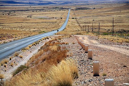 纳米比亚的公路日出驾驶环境地平线速度旅行小路土地岩石天空图片