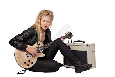 摇滚女孩玩电吉他牛仔裤女性演员夹克乐趣音乐家吉他手乐器膝盖皮革图片
