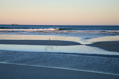 日出在沙滩上海岸天空地平线海洋日落太阳海浪图片