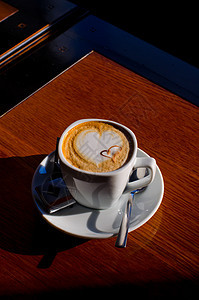 卡布奇诺时间拿铁叶子桌子泡沫巧克力咖啡师杯子咖啡馆牛奶早餐图片
