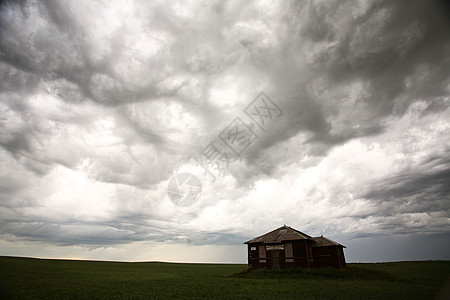 暴风在萨斯喀彻温一栋老旧的乡村住宅上云雾植被草原农场天气场地天空风暴旅行建筑水平图片