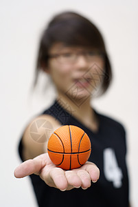 亚洲青少年手握着小橙子篮球背景图片