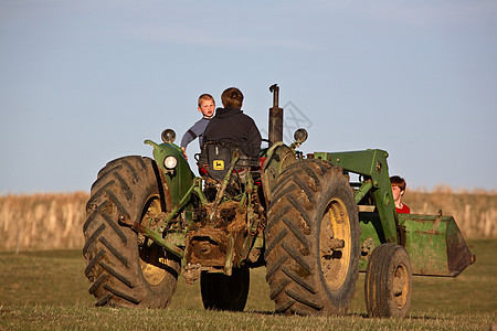 萨斯喀彻温省与父亲一起搭拖拉机的儿童乡村旅行国家农村农场大草原场景机械农业照片图片