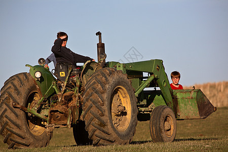 萨斯喀彻温省与父亲一起搭拖拉机的儿童乡村场景汽车农业旅行大草原农场国家机械风景图片