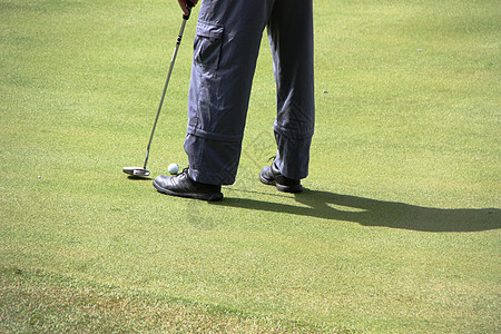 一个想打球的高尔夫球手草地运动专注衣服服装场地阴影玩家摇摆俱乐部图片