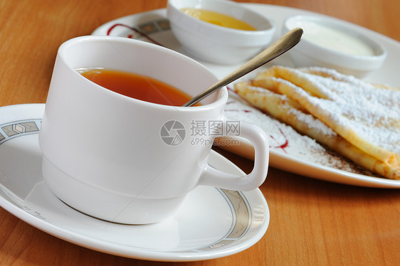 含奶粉糖的茶和煎饼蛋糕油炸早餐烹饪糕点勺子化合物杯子餐具桌子图片