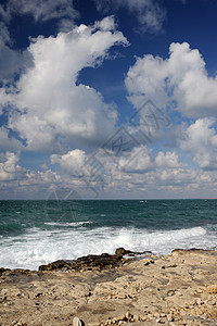 海岸石块的波浪蓝色阳光休息岩石气泡天空假期泡沫海景飞溅图片