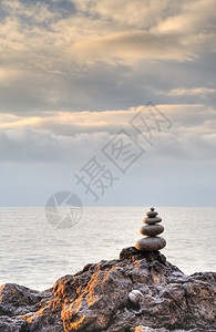 戏剧性天空背景的石头和石块假期场景卵石阳光旅行平衡温泉自由海滩巨石图片