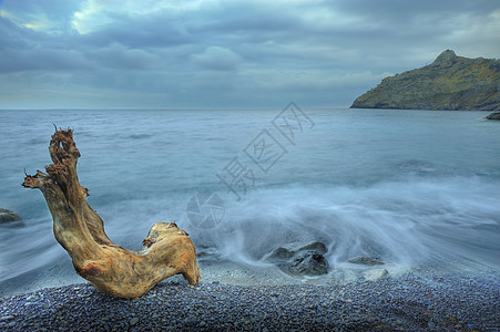 木头与石头夜间的海水和木材岩石薄雾海浪场景巨石假期海景风暴卵石云景背景