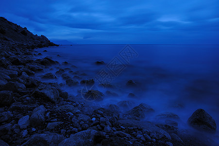 夜间的海蓝色海滩地平线海浪日落石头阳光场景天空边缘图片