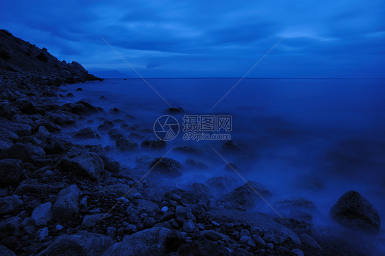 夜间的海蓝色海滩地平线海浪日落石头阳光场景天空边缘图片