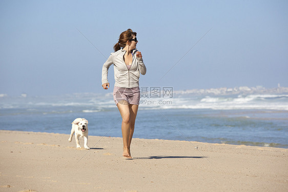 女孩带着可爱的狗闲暇海岸动物猎犬友谊宠物微笑跑步小狗海滩图片