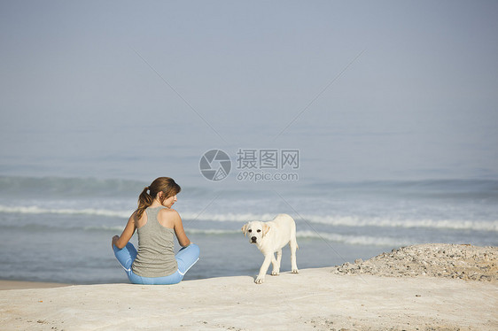 女孩带着她的狗自由小狗猎犬宠物闲暇海滩海岸动物海洋假期图片