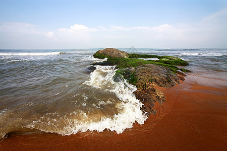 湿宝石岩石海洋季节海滩圆形海岸石头太阳蓝色背景图片