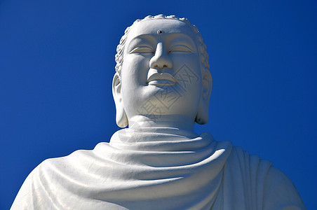 佛文化瑜伽微笑雕刻石头雕塑佛教徒天空大理石蓝色背景图片