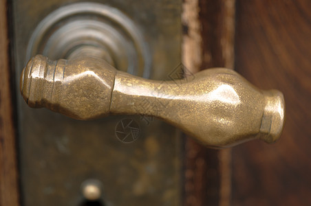 古老的铜门把柄在木制门上图片